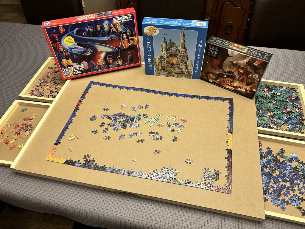 Puzzle table with three puzzles on it. 